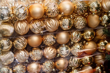 Golden Christmas ornament balls baubles in a plastic boxes. Christmas shopping concept. Holiday background.