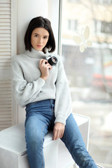 Portrait of a beautiful young woman with a camera, lifestyle