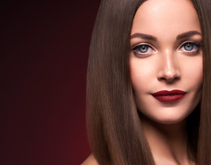 Obraz premium Beauty face female red lops long smooth hair red dark background