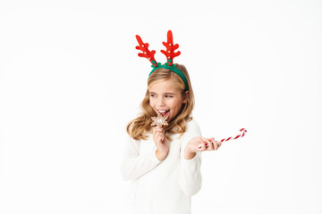 Image of girl in Christmas reindeer antlers holding New Year sweets