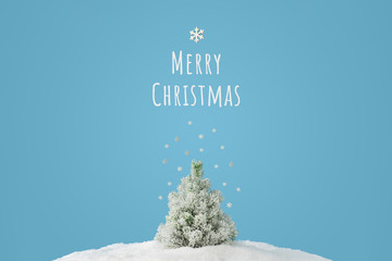 Creative layout with snowy Christmas tree on bright blue background. Minimal winter nature holiday...