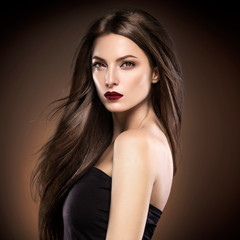 Fototapeta premium Beautiful hair woman long smooth hairstyle red lipstick brown backrgound
