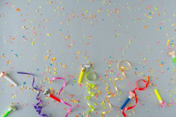 Creative composition made with colorful party streamers and confetti on pastel grey background....