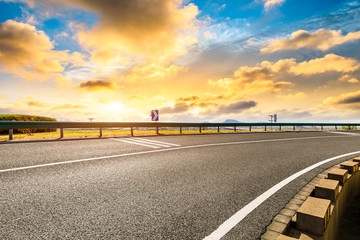Fototapeta premium Asphalt road and beautiful sky at sunset