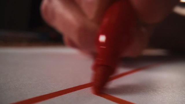 Drawing with red marker pen on paper, close up macro