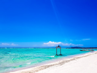 Gili Islands, Indonesia, Asia. Beautiful beach crystal clear water and white sand in an exotic tropical destination. Famous wooden water swing. Popular instagram location. 