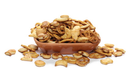 Salty cracker and pretzel snacks, party mix in clay bowl, pot isolated on white background