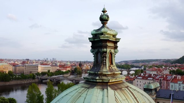 Aerial view Vltava river and bridges in Prague at daytime. Drone flying at low above roof of Straka Academy, lateral motion shot manes bridge through Vltava river and buildings on embankment 