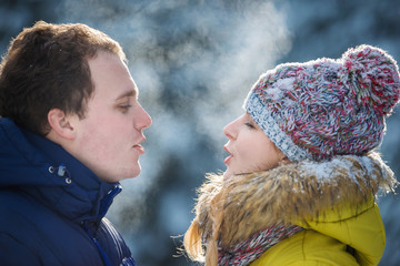 Fresh breath in frozen winter day of young happy couple. Couple breath outdoor in winter