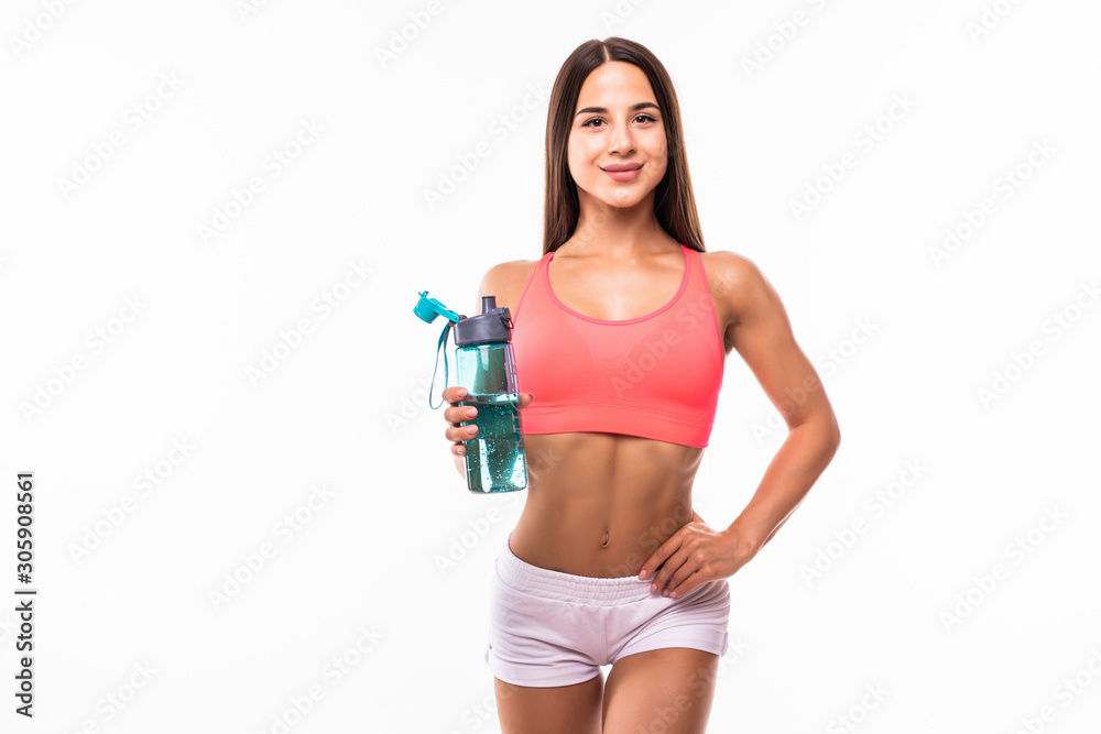 Wall mural sporty muscular woman drinking water against white background