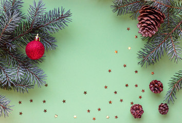 Christmas flatlay with green christmas tree branches, cones and red ball. New Year. Top view