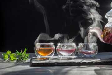 Tea time to brew loose-leaf or flower . dark mood.Hot water is poured from the kettle into a cup with tea leaves.