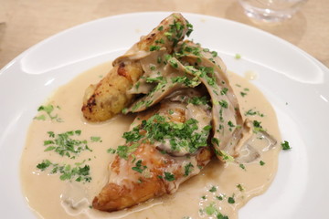 Poulet grillé sauce aux morilles dans une assiette blanche