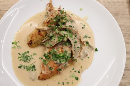 Poulet grill&eacute; sauce aux morilles dans une assiette blanche
