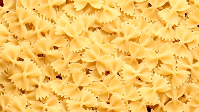 Pile of raw italian farfalle pasta rotating in circle