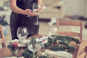 woman is waiting for guests and sets the table. festive laying table, preparation for christmas dinner.