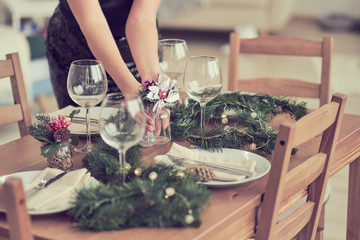 woman is waiting for guests and sets the table. festive laying table, preparation for christmas dinner.