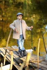 Kid fishing in a river, sitting on a wood pontoon