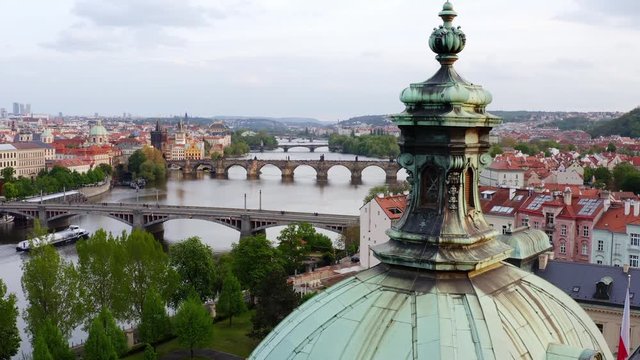 Aerial view Vltava river and bridges in Prague at daytime. Drone flying at low above roof of Straka Academy, Picturesque cityscape manes bridge through Vltava river and buildings on embankment 