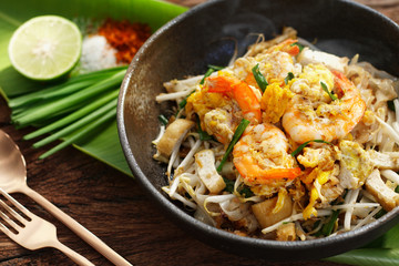 Thai traditional food: Still life of Pad Thai, stired noodles with shrimps, egg served with lime,vegetable. Pad Thai is popular on street food, Thailand, Clean food good taste concept.