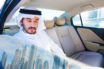 Arab man inside car riding vehicle concept. Middle East guy on kandoora dish dash using uber