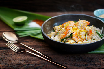 Thai traditional food: Pad Thai, stired noodles with shrimps, egg served with lime, vegetable. Pad Thai on street food, Thailand, Clean food good taste concept.