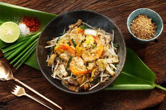 Thai traditional food: Still life of Pad Thai, stired noodles with shrimps, egg served with lime,vegetable. Pad Thai is popular on street food, Thailand, Clean food good taste concept.