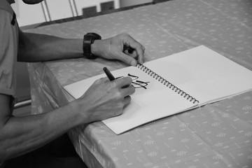 hand with pen writing on paper