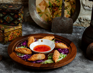 fried gurza dumplings served with sweet chili sauce and carrot slices