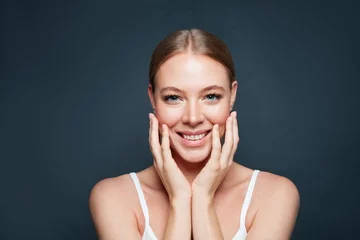 Beautiful woman face on blue background. Happy woman model smiling