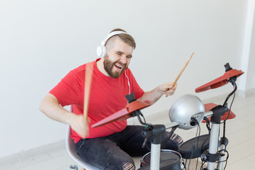 Music, hobby and people concept - young man drummer playing the electronic drums