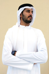 Arab man wearing Emirati Kandoora. Modern Arabic MIddle Eastern man smiling on isolated background wearing traditional UAE dress