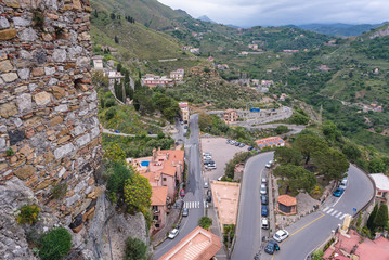 Walls of old castle and hairpin road in Castelmola, small town on Sicily Island, Italy