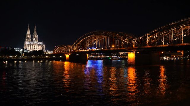 Time lapse of the illuminated Hohenzollern bridge over Rhine river. Beautiful cityscape of Cologne, Germany  with cathedral at night.