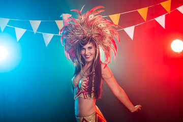 Carnival, belly dance and holiday concept - Beautiful female samba dancer wearing gold costume and smiling
