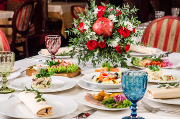 Empty glasses set in restaurant. Served for holiday banquet restaurant table with dishes, snack, salads, cutlery, wine and water glasses. European food