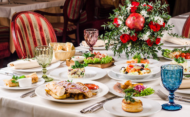 Beautiful restaurant interior table decoration for wedding or event. Flower Wedding Table Decoration, Autumn colors. European food in a restaurant setting. Table set for party.