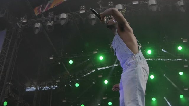 Black rapper in overalls on stage