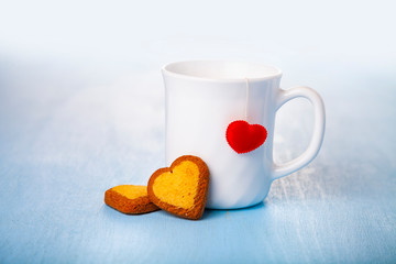 White cup with a heart and cookies.