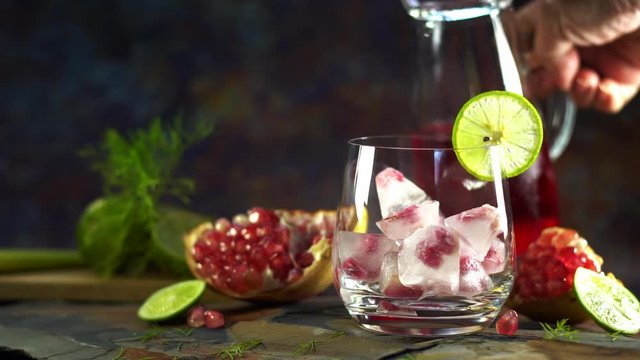 Still life photography of Pomegranate juice lemon soda with pomegranates seeds on table. Shooting at studio,low key toned image, Selective focus and free space for text. Healthy fruits drink concept.