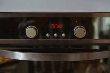 Obraz premium Electric oven with clock isolated in the kitchen.