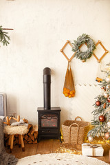 Christmas decoration of farmer house. New Year's interior. wooden frames on the wall, a wreath of fir branches, tangerines in an eco bag. The atmosphere of celebration and comfort.