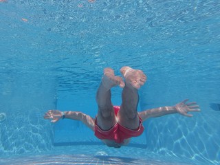 man snorkeling in blue crystal clears waters of a beach of mallorca