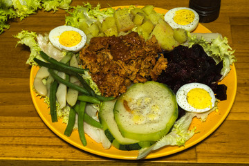Préparation pour assiette avec betterave rouge radis noir tomate pomme de terre œuf salade haricot vert courgette