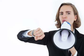 A beautiful business woman in a suit is shouting at a megaphone and raising her arm to show punctuality by watching the clock on a white background in the concept of business success.