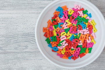 multicolored wooden letters in a plate