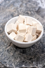 Organic Raw Soy tofu cheese close-up on stone background