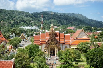 View of the traditional Asian pagoda. A white building with gold trim and a red roof against the sky. Buddhist temple facade in Thailand.