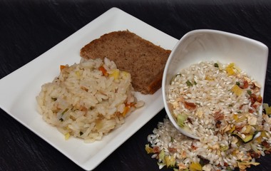 risotto with dried vegetables in a white plate, dry and boiled on a black background