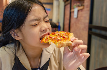Asian children eat pizza